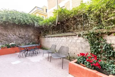 a patio with chairs and a table and flowers at Rome Apartment San Pietro - Monte del Gallo in Rome