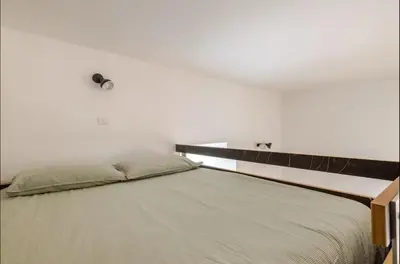 a bed in a bedroom with a white wall at Rome Apartment San Pietro - Monte del Gallo in Rome