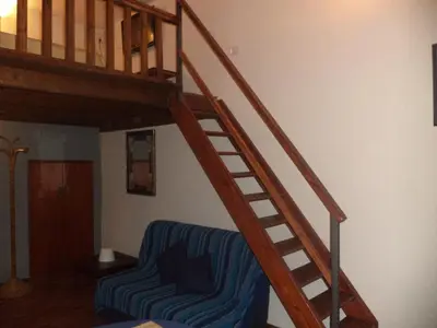 a wooden staircase with a blue couch and a blue chair at Jacuzzi Quo Vadis in Rome