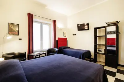 a hotel room with two beds and a window at Old Kitchen Vatican Suites in Rome
