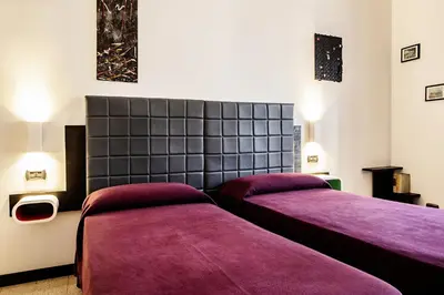 two beds in a room with purple blankets at Old Kitchen Vatican Suites in Rome