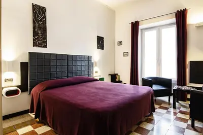a bedroom with a bed with a purple blanket at Old Kitchen Vatican Suites in Rome