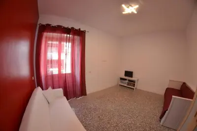 a living room with a red curtain and a couch at Bed&bookofrome in Rome