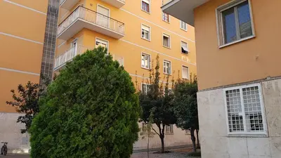 a large yellow building with a tree in front of it at Bed&bookofrome in Rome