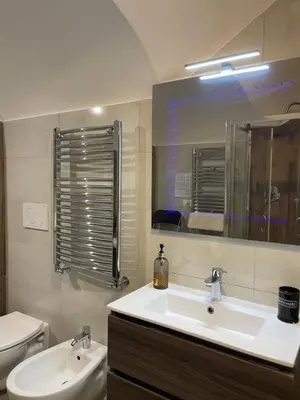 a bathroom with a sink and a toilet and a mirror at Delizioso Appartamento in Via di Monte Verde in Rome