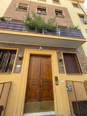 a building with a wooden door with plants on it at Delizioso Appartamento in Via di Monte Verde in Rome