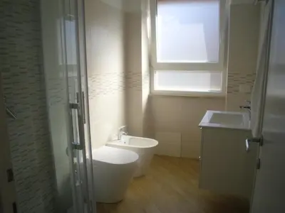a bathroom with a toilet and a sink and a window at Lovely Little Apartment in Via Aurelia in Rome