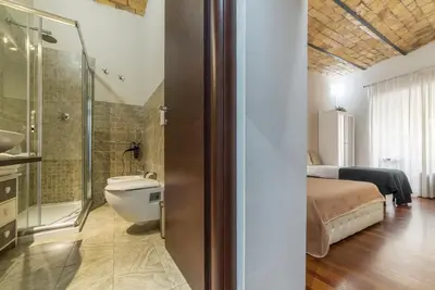 a bathroom with a toilet and a shower and a bed at Residenza Sistina in Rome
