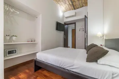 a white bedroom with a bed and a tv at Residenza Sistina in Rome