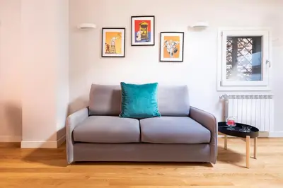 a couch in a living room with a blue pillow at Residenza Palline by Hili in Rome