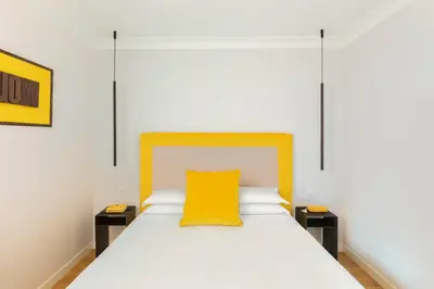 a bedroom with a bed with a yellow pillow on it at Residenza Palline by Hili in Rome