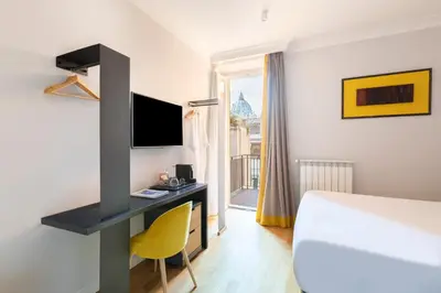 a hotel room with a bed and a desk with a tv at Residenza Palline by Hili in Rome