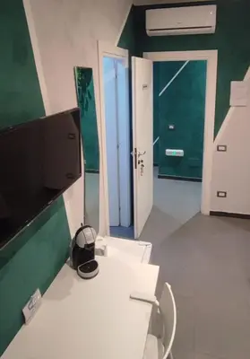 a bathroom with a white toilet and a green wall at Eden guest house in Rome