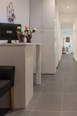 a corridor of an office with flowers in vases on a counter at Eden guest house in Rome