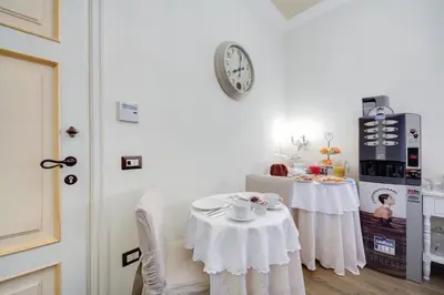 a dining room with two tables and a clock on the wall at Lunaria Suites Rome Vaticano in Rome