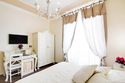 a bedroom with a bed and a chandelier at Lunaria Suites Rome Vaticano in Rome