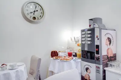 a kitchen with a table and a clock on a wall at Lunaria Suites Rome Vaticano in Rome