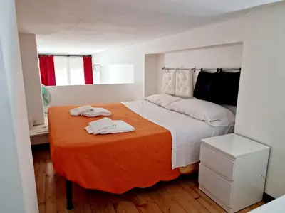 a bedroom with a bed with an orange blanket at Lofts In Rome in Rome
