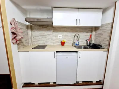 a small kitchen with white cabinets and a sink at Lofts In Rome in Rome