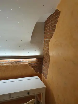 a room with a brick wall and a white desk at Vicolo Navona in Rome