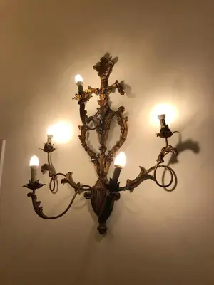 a chandelier with candles hanging on a wall at Stylish apartment in central Rome 