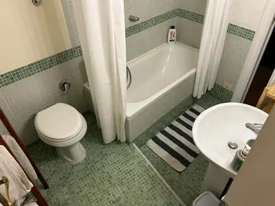 a bathroom with a toilet and a tub and a sink at Stylish apartment in central Rome 