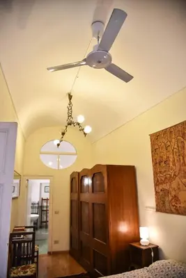 a ceiling fan in a room with a bed at Stylish apartment in central Rome 