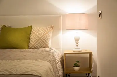 a bed with a green pillow and a lamp on a night stand at Lovely New home, Trastevere! in Rome