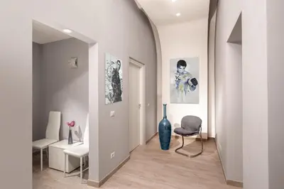 a hallway with a blue vase and a chair at Well Done Montebello in Rome