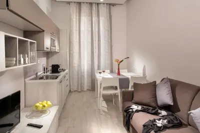 a kitchen and living room with a couch and a table at Well Done Montebello in Rome