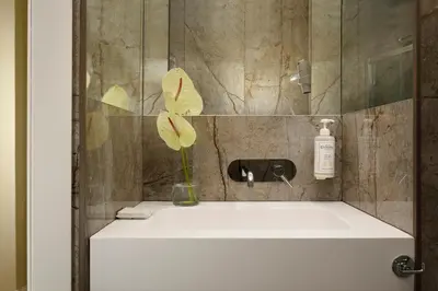 a bathroom sink with a vase with a flower in it at Velantia Vaticano - Guesthouse in Rome