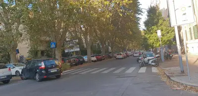 a street with cars parked on the side of the road at B&B Lumiere Roma in Rome