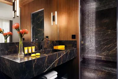 a bathroom with a black marble counter and a sink at The First Dolce - Preferred Hotels & Resorts in Rome
