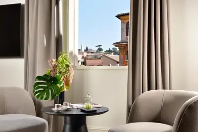 a room with two chairs and a table and a window at The First Dolce - Preferred Hotels & Resorts in Rome
