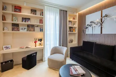a living room with a black couch and a chair at The First Dolce - Preferred Hotels & Resorts in Rome