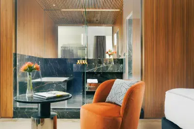 an orange chair and a table in a room at The First Dolce - Preferred Hotels & Resorts in Rome