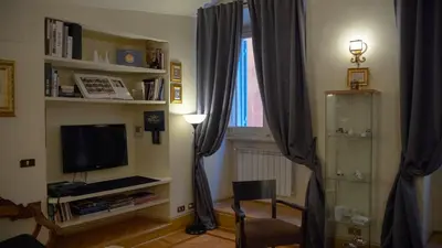 a living room with a television and a window at MGPGroup Guest House Navona in Rome