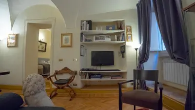a living room with a tv and a chair at MGPGroup Guest House Navona in Rome