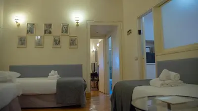 a hotel room with two beds and a table at MGPGroup Guest House Navona in Rome