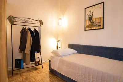a bedroom with a bed and a rack of clothes at Amazing Trevi Fountain in Rome