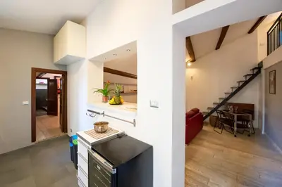 a kitchen and living room with a staircase in a house at CasaJusta Trastevere in Rome
