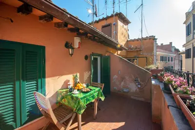 a balcony with a table and chairs on a building at CasaJusta Trastevere in Rome
