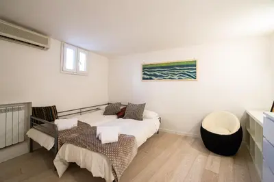 a living room with two beds and a table at CasaJusta Trastevere in Rome