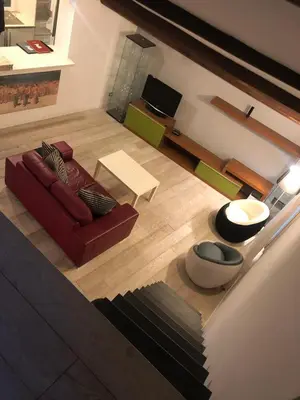 a living room with a red couch and a table at CasaJusta Trastevere in Rome