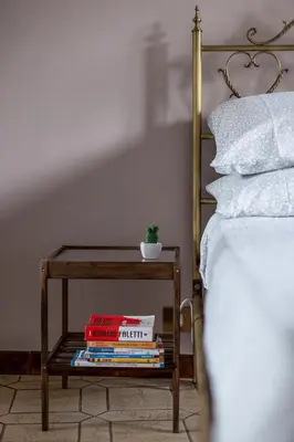 a table with books on it next to a bed at Piazza Bologna in Rome
