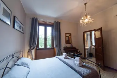 a bedroom with a bed and a window and a chandelier at Piazza Bologna in Rome