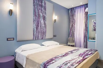 a bedroom with a bed and a painting on the wall at Gracchi Guest House in Rome