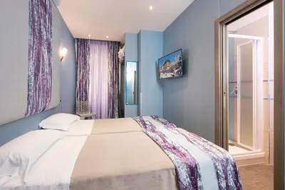 a bedroom with a bed with blue walls and a window at Gracchi Guest House in Rome