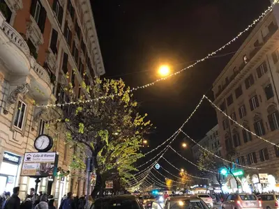a busy city street with christmas lights and a clock at Gracchi Guest House in Rome