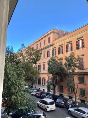 a large building with cars parked in a parking lot at Gracchi Guest House in Rome